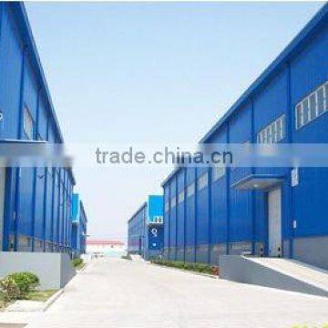 Large Prefab Factory with Metal Frame Blue Cladding Short Brick Wall