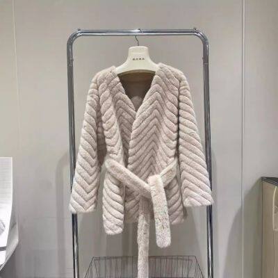 Ein neues Minkpelzmantel für Frauen, ein umweltfreundlicher einteiliger Pelzmantel, der der Figur folgt und einem einen schlanken Anschein verleiht. Es ist ein kurzer Mantel. photo-2