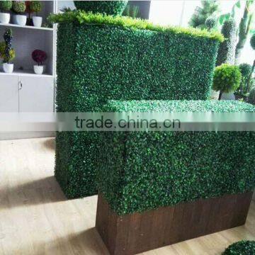 Vertical artificial plastic green wall and hanging decorations