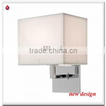 single wall sconce with white fabric shade and chrome backplate