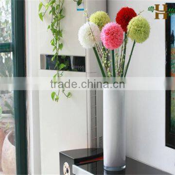 Handmade cylinder colored glass vase with flower arrangement