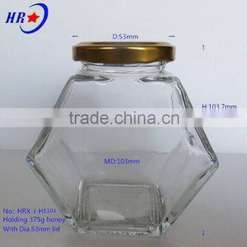 holding 375g Honey glass jar with golden lid