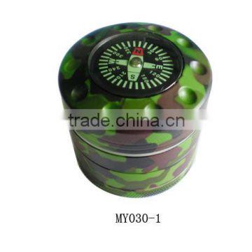 metal green around cigarette grinder with compass