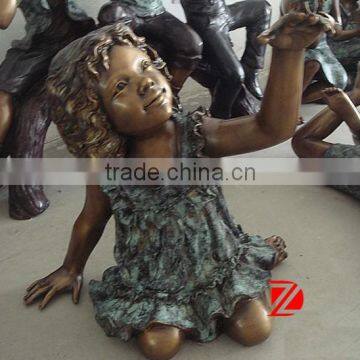 Bronze cute baby girl statue on floor playing