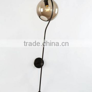 A Hand-blown Fish Mouse Glass Ball is Cupped By a Long Brass Arm Wall Lamp Fiddlehead Balance Wall Lights