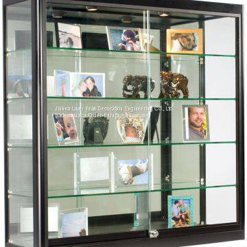 Glass Display Case That Is Wall Mounted, Illuminated, Has Locking Sliding Glass Doors, And Ships Fully Assembled