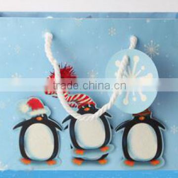 3 Penguins in blue paper bag making 2014