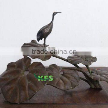 Bronze bird staying on lotus sculpture