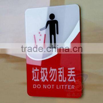 red color no litter warning sign board with stickers on the wall