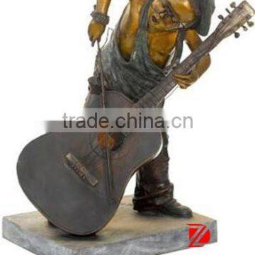 bronze little boy statue with glasses playing guitar