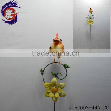 Shining metal bird standing on stick with metal garden decorative windmill