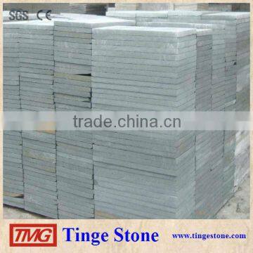 Cut to size green sandstone tiles and brick for paving