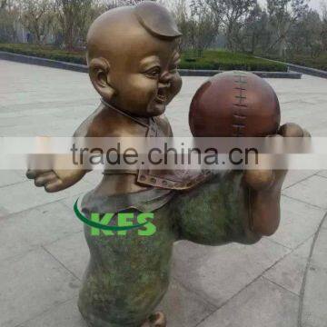 Bronze boy playing football sculpture