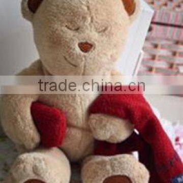 cut plush squinting bear toy wearing red towel