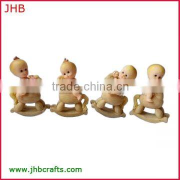 Baby figurine sitting on rocking horse