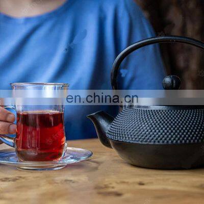 Black Cast Iron Tea Pot With Herbal Tea Set up Dark Stone Background