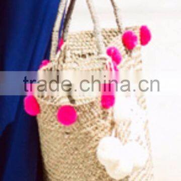 Natural seagrass plant beach bag with white and pink pompoms made in Vietnam