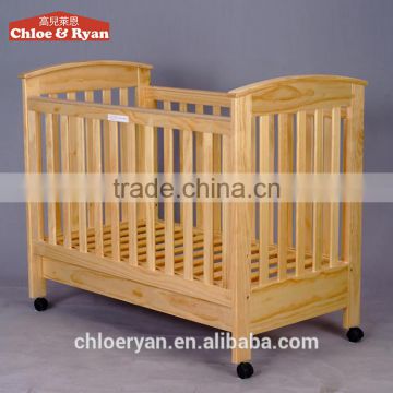 wooden convertible crib with a large storage drawer