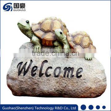 Welcome sign rock with tortoise garden statue