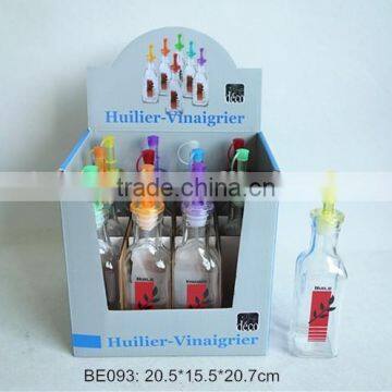 square glass bottle with plastic lid used for oil in a display box
