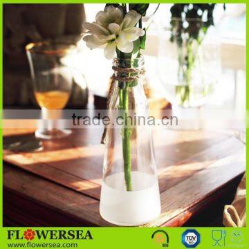 white and transparent glass vase with rope decoration and artificial flower